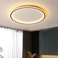 Slim round ceiling light with a black rim, glowing warm white in a room with dark panelling 2