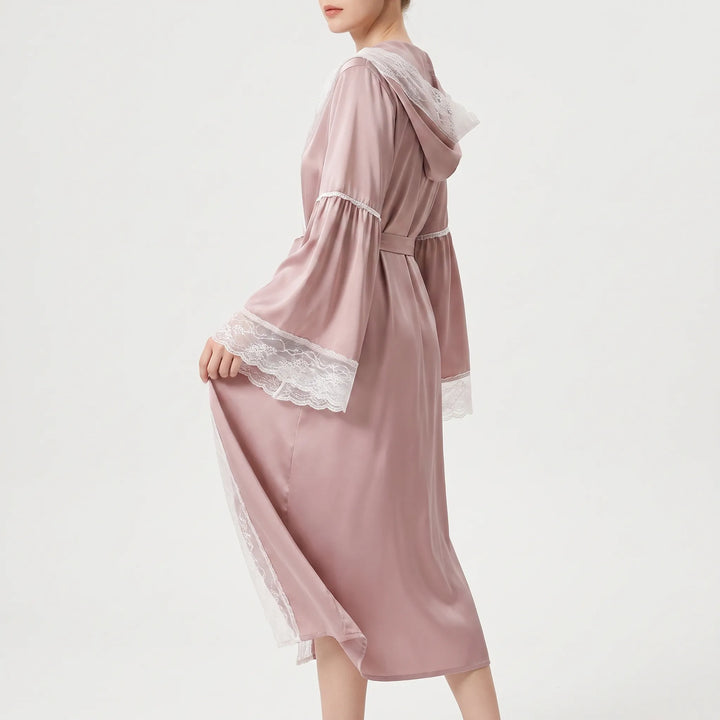 Model seen from the side in the pink satin robe, tied at the waist, lifting the lace-trimmed sleeve. 3