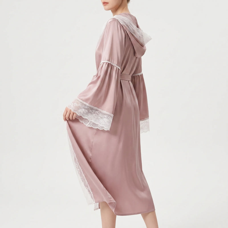 Model seen from the side in the pink satin robe, tied at the waist, lifting the lace-trimmed sleeve. 3