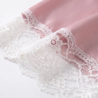 Close-up of white floral lace trim on the pink satin fabric, showing its scalloped edge and mesh detail. 4