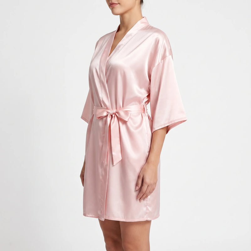 Side view of the pink robe worn by a model, with the belt tied in a bow and sleeves falling to the elbow. 4