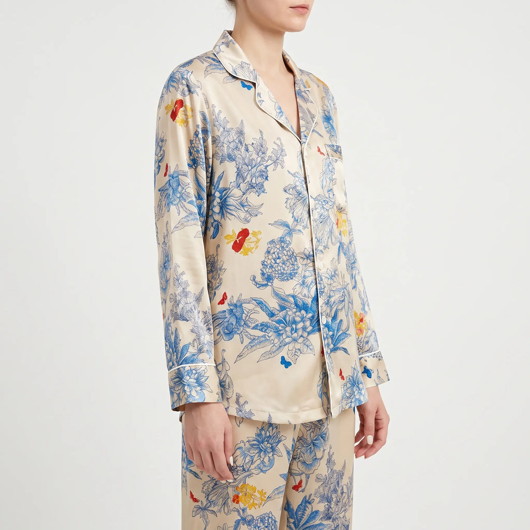 Three-quarter side view of a model in the long-sleeve floral pyjama shirt with notched collar, chest pocket and white piping. 4