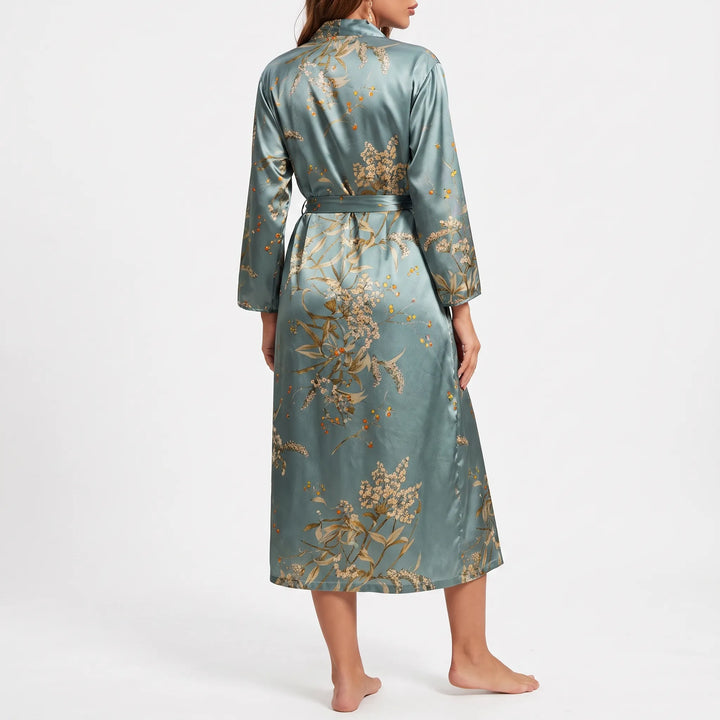 Back view of a model wearing the teal satin robe, showing the large floral print across the back and sleeves. 3