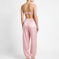 Back view of the pink satin set on a model, showing thin adjustable straps, the elastic band of the bralette and pants. 3
