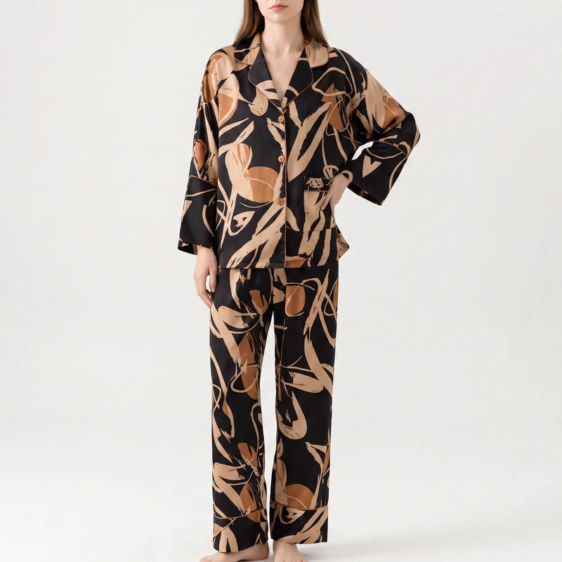 Front view of a model standing with one hand on her hip, wearing the black and tan abstract print pyjama set. 5