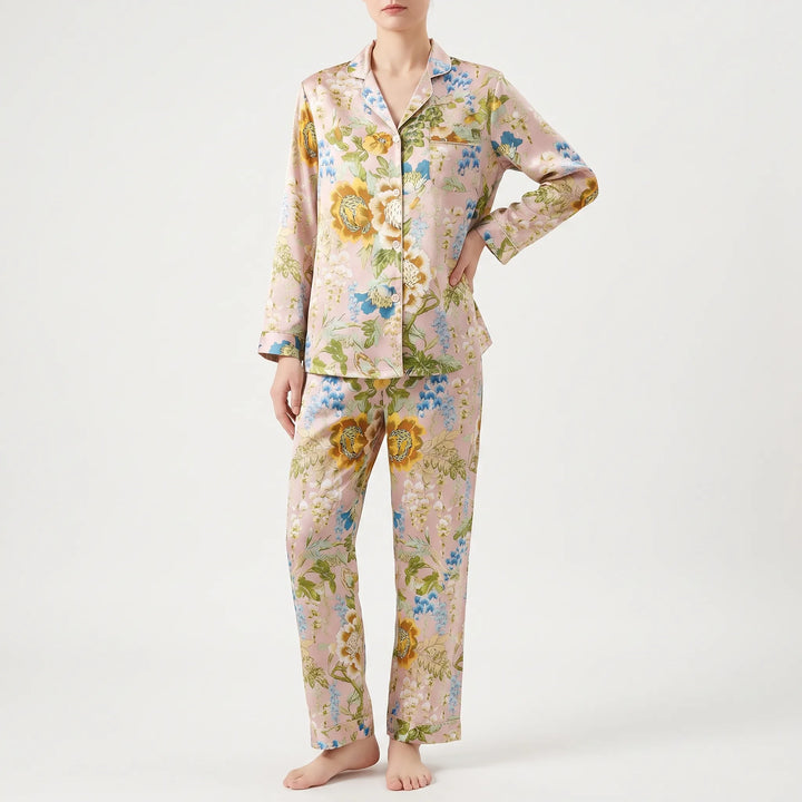 Front view of a model with one hand on her hip, wearing the long sleeve floral pyjama shirt with matching trousers. 5