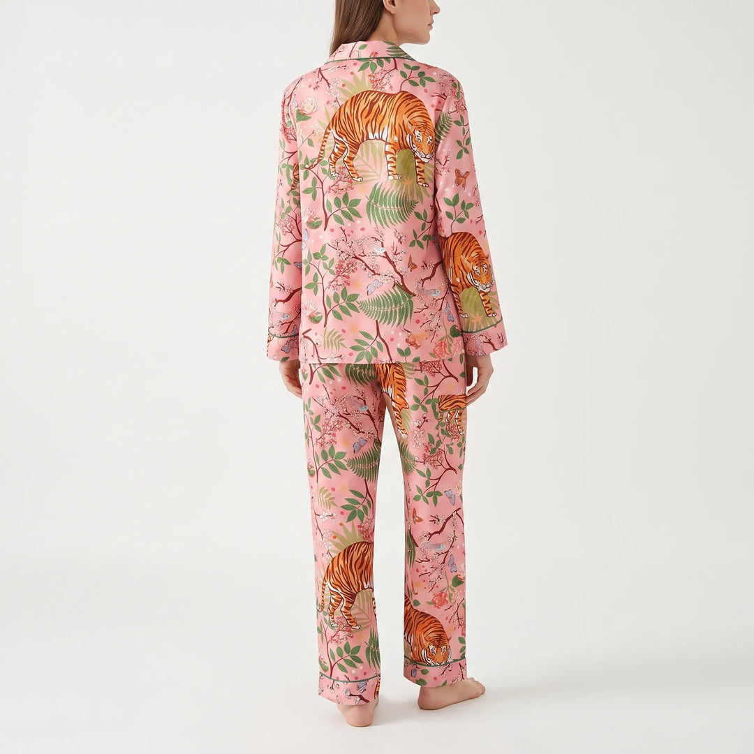Back view of the pink pyjama set on a model, with a large tiger print across the shirt and trousers. 2