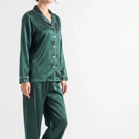 Three-quarter side view of the green satin pyjama set on a model, showing the notched collar, buttons and pocket. 4