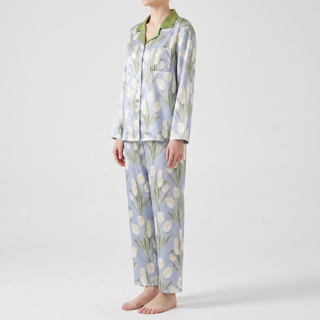 Side view of a model wearing the blue tulip-print pyjama set, with green collar, chest pocket and relaxed straight-leg trousers. 4