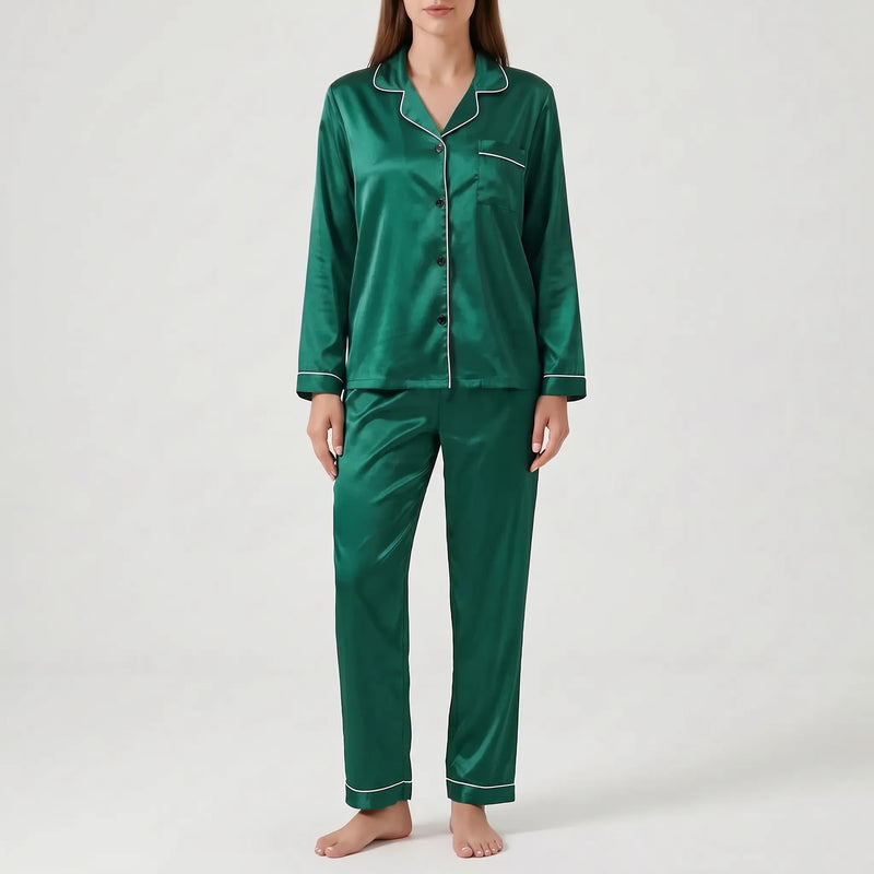 Model wearing the satin pyjama set in emerald green with white piping and dark buttons, front view. 10