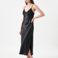 Model with hand on hip wearing the nightdress in black satin, with lace-trimmed pleated bodice, small bow and side slit. 10