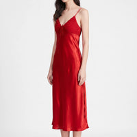 Red satin nightdress on a model against white, showing the pleated lace-edged V-neck bodice, small bow and thin straps. 2