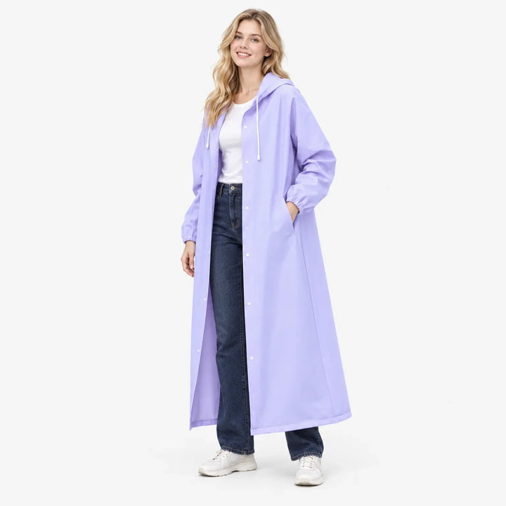 Smiling woman in the lilac hooded raincoat worn open over jeans, one hand in a side pocket, studio three-quarter view. 4