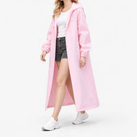 Woman walking in the pink hooded raincoat worn open over a white tee and denim shorts, shown from the side. 5