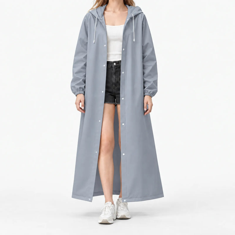 Studio front view of the grey-blue hooded raincoat worn open with white snaps and drawstrings over a white top and shorts. 8