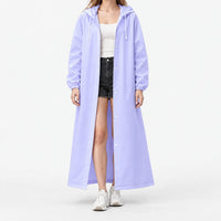 Studio front view of the lilac hooded raincoat worn open over a white ribbed top, black shorts and white sneakers. 9