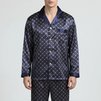 Close front view of the navy satin pyjama shirt with notched collar, chest pocket, light buttons and contrast cuffs. 2