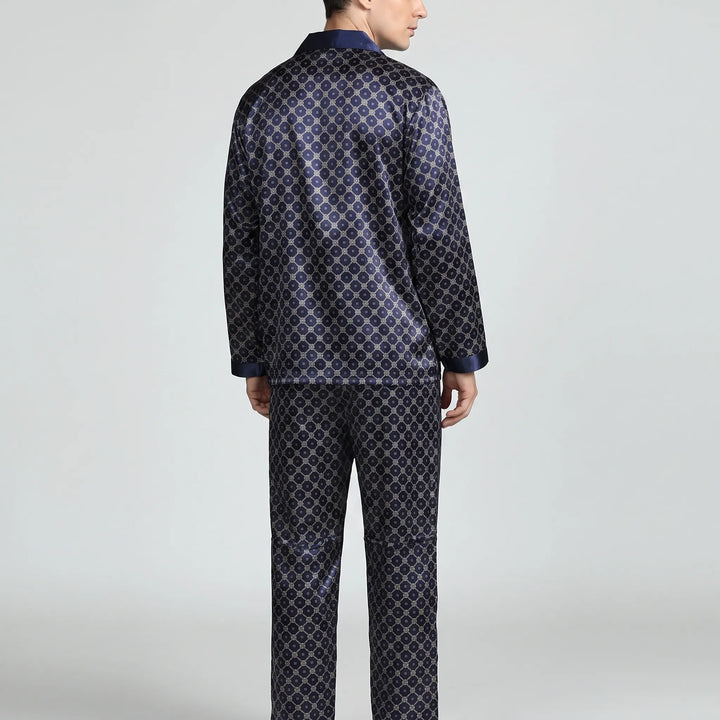 Back view of the navy lattice-print pyjama set on a model, showing the plain back of the shirt and trousers. 3
