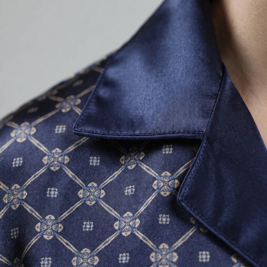 Close-up detail of the navy satin collar with piped edge, next to the printed lattice and small floral motifs. 5