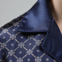 Close-up detail of the navy satin collar with piped edge, next to the printed lattice and small floral motifs. 5