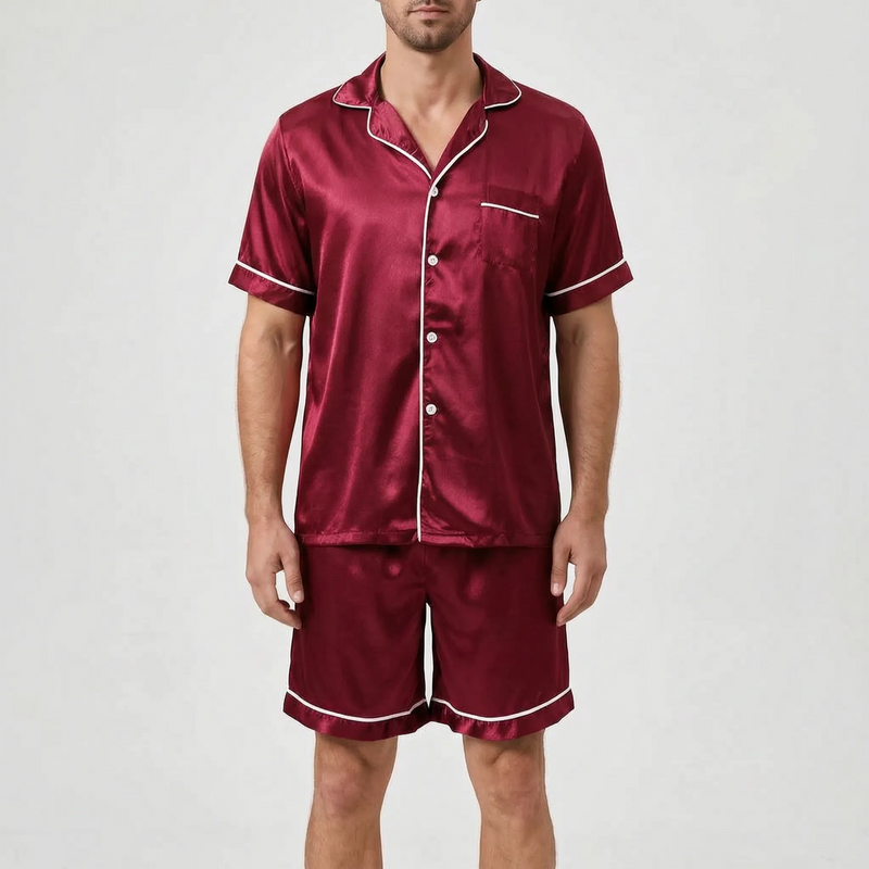 Model wearing the pyjama set in burgundy satin with white piping and white buttons, front view. 11