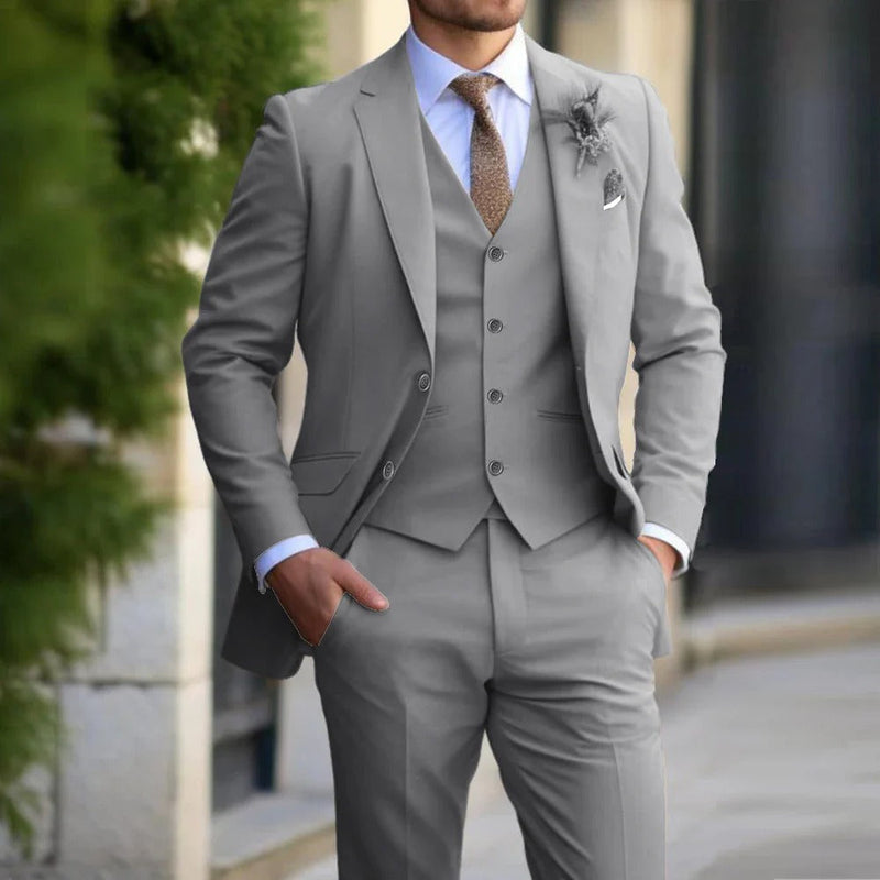 Model wearing the suit in light grey, with white shirt, brown tie and a floral lapel pin 2