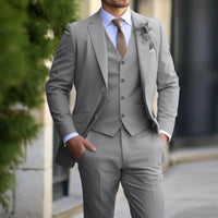 Model wearing the suit in light grey with waistcoat, white shirt and brown tie, hand in pocket 3