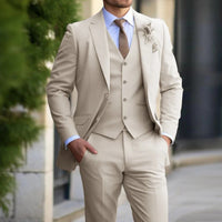 Close crop of a model wearing the beige suit with waistcoat, hands in pockets, on a city street 2