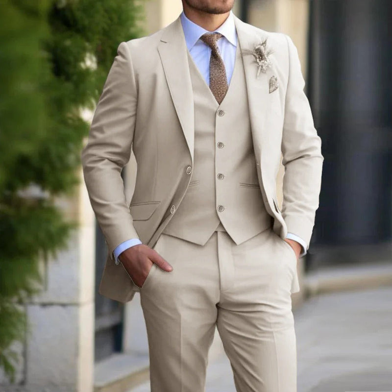Close crop of a model in the beige three-piece suit, buttoned waistcoat, brown tie and floral lapel pin 2