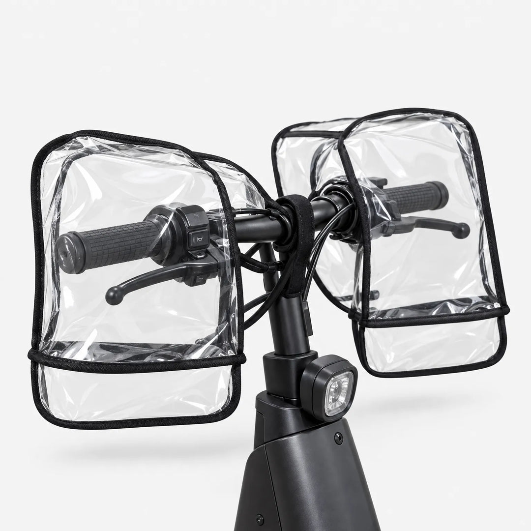 Rear view of clear transparent muffs covering both grips and brake levers of a black scooter handlebar, shown on a white background. 4