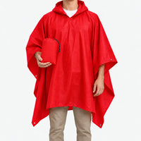Red version of the hooded poncho worn on a model, who holds the matching red drawstring pouch. 6