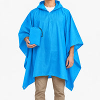 Bright blue version of the hooded poncho worn on a model, who holds the matching blue drawstring pouch. 9