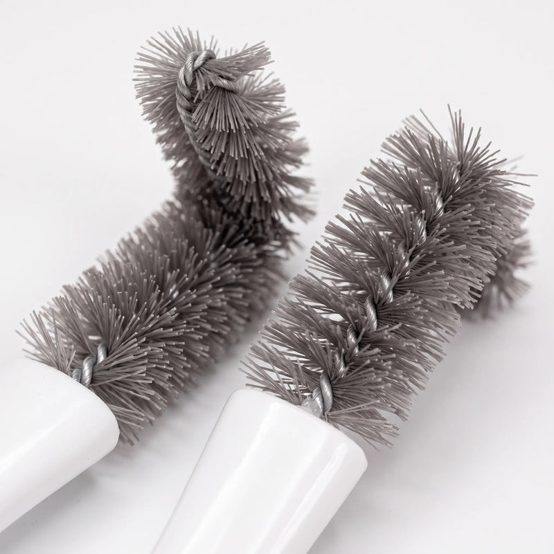 Close-up of two grey twisted-wire brush heads with dense, soft bristles, one bent at a right angle, against a white background. 3