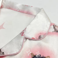 Close-up of the satin collar with pink piping and part of the kitten print on a white background. 5