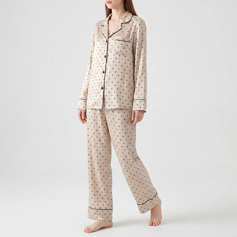 Full-length front view of a model walking barefoot in the buttoned long-sleeve pyjama shirt and wide-leg trousers against a plain background. 2