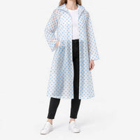 Model in the translucent blue polka dot raincoat worn open over a white tee, one hand in a pocket, studio shot. 2