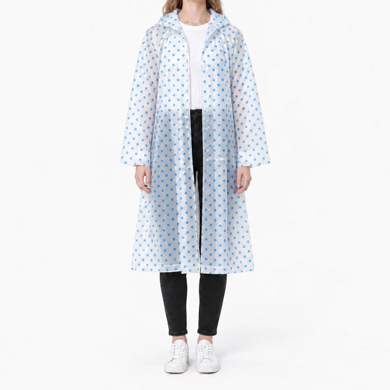 Front view of the translucent raincoat with blue polka dots, worn open over a white tee and black jeans. 9
