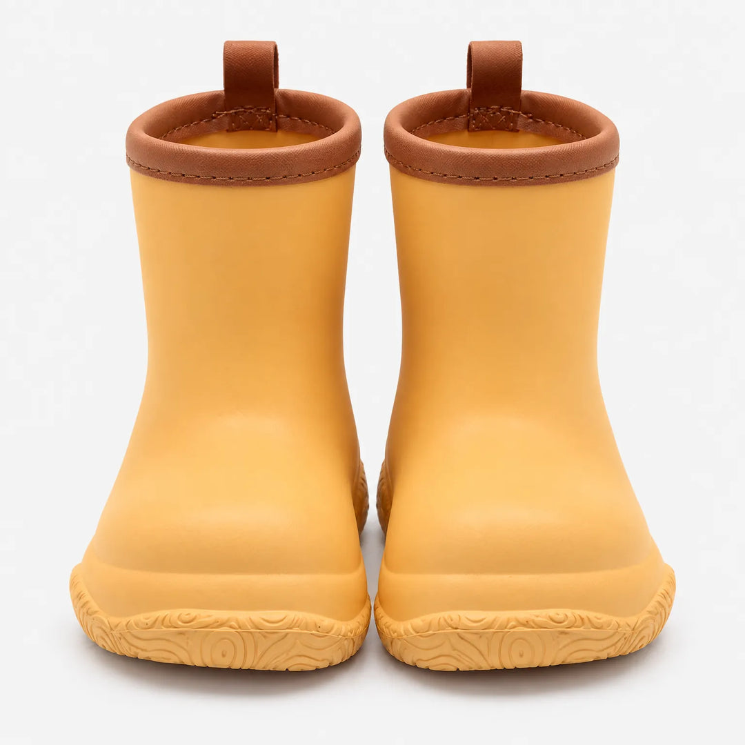 Front view of a pair of yellow-orange wellies with brown stitched collars, brown pull loops and a swirl-patterned sole. 11