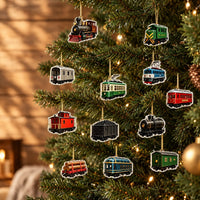 Colourful train and railcar ornaments in steam, tram and freight shapes hanging from gold cords on a lit Christmas tree. 1