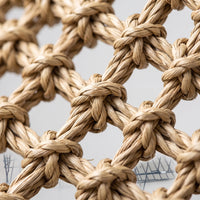Close-up of the hammock's knotted, twisted natural-fibre weave, showing the open diamond-shaped mesh and texture of the strands. 3