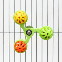 Green spinner with yellow, lime and orange bell balls mounted on the metal bars of a cage, shown against a white background. 5