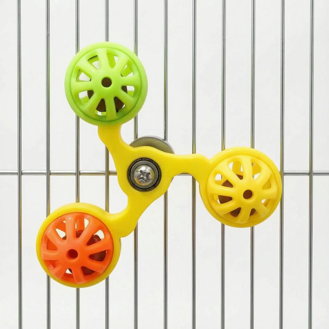 Yellow-framed version of the spinner with green, yellow and orange bell balls, attached to the bars of a metal cage. 6