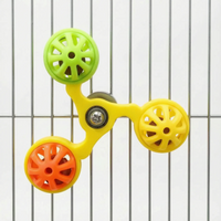 Yellow-framed version of the spinner with green, yellow and orange bell balls, attached to the bars of a metal cage. 6