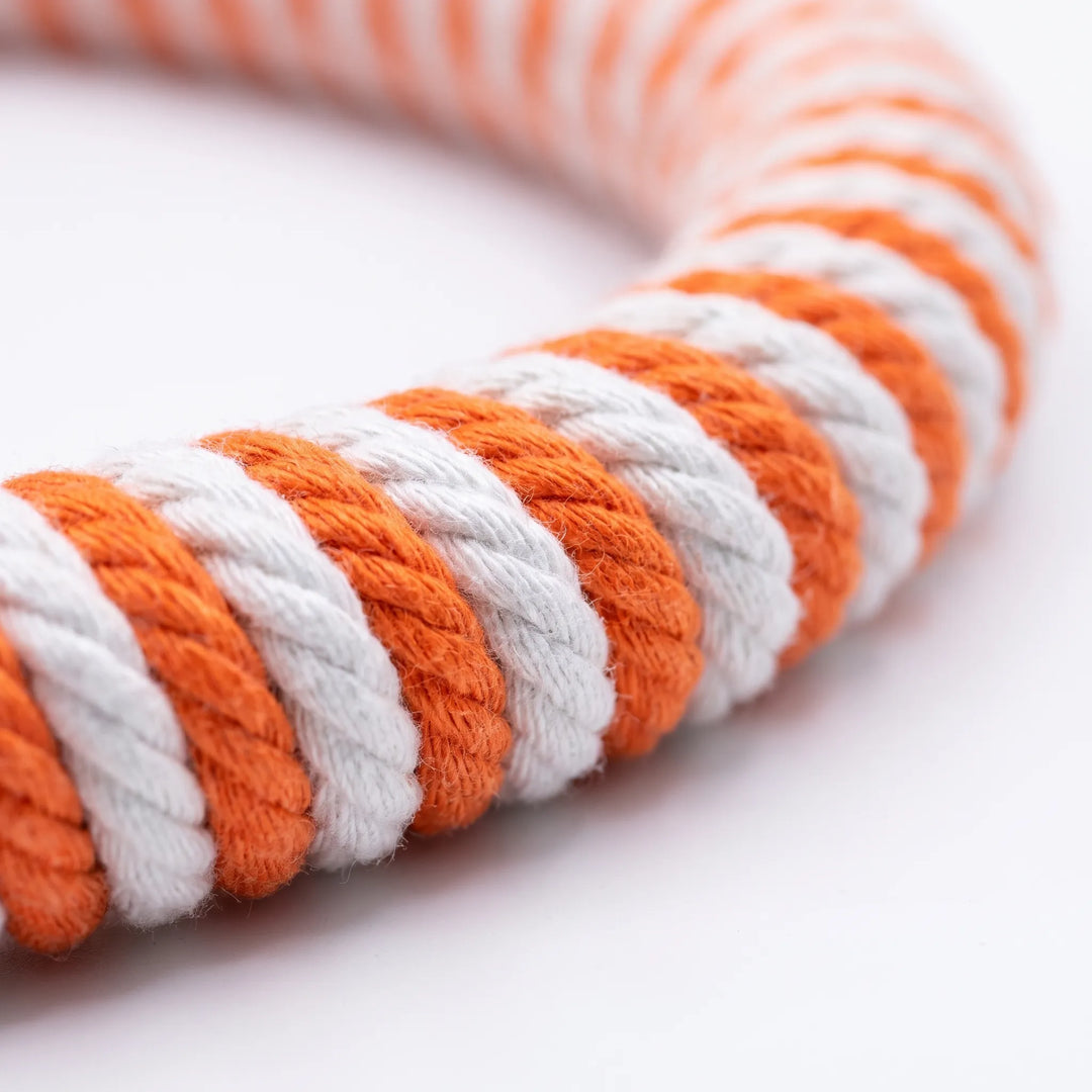 Close-up of the twisted orange and white cotton rope winding around the ring, showing the braided texture. 3