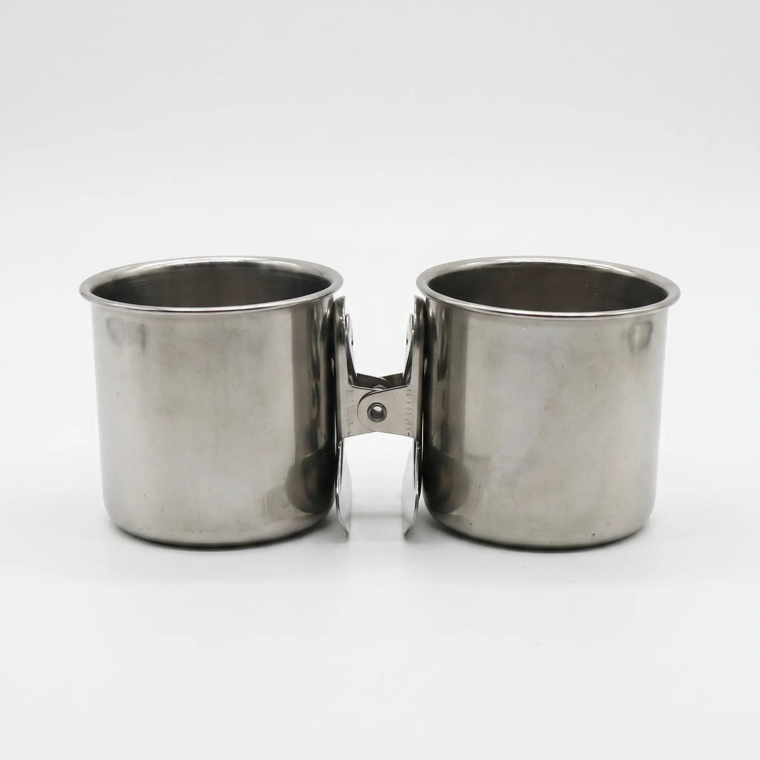 Two steel cups placed side by side on a white background, their clips facing each other in the middle. 5
