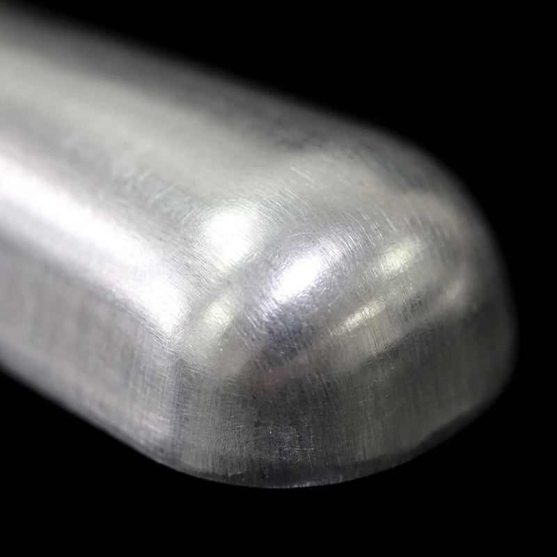 Close-up of the scoop's rounded metal end, showing a brushed, lightly scratched surface against a black background. 3