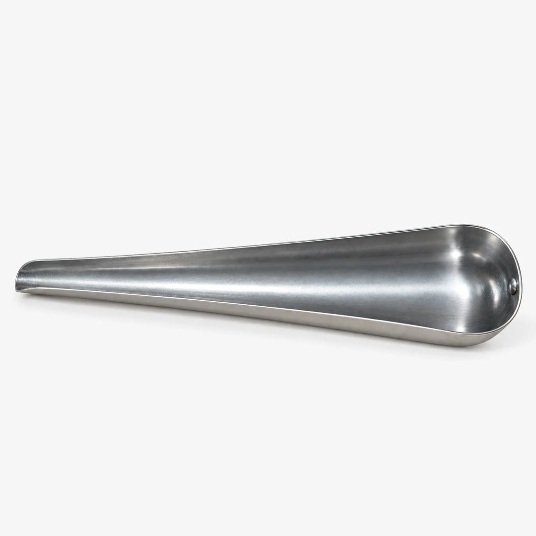 Empty tapered metal scoop lying on its side against a white background, showing the open channel and narrow spout. 4