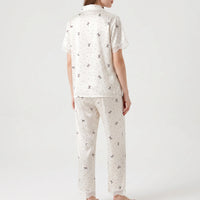 Back view on a model showing the bow and polka dot print across the top and trousers, with lace at sleeves and hems. 3