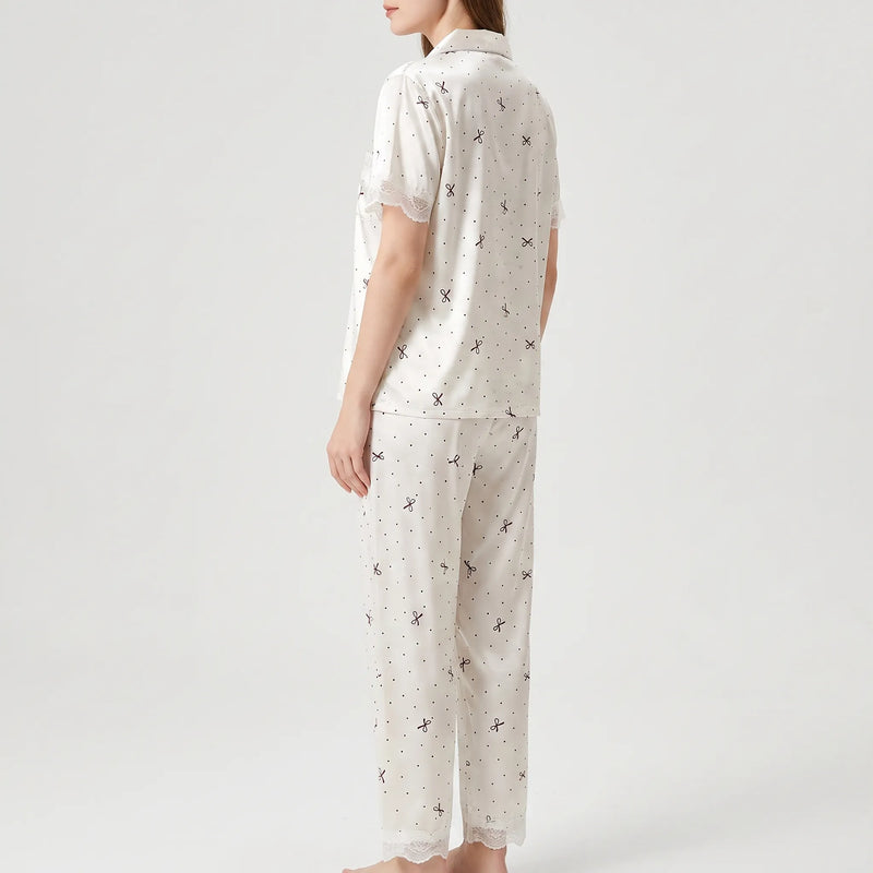 Three-quarter back view of the pyjama set worn by a model, showing the lace-trimmed sleeve and trouser hem. 4