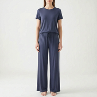 Model standing in the set in deep navy blue, with a short-sleeved top and drawstring wide-leg trousers, front view. 11